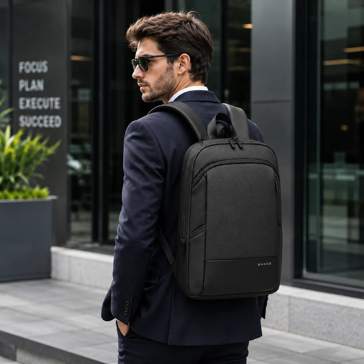 Jeune entrepreneur portant un sac à dos ordinateur BANGE noir dans un environnement professionnel urbain