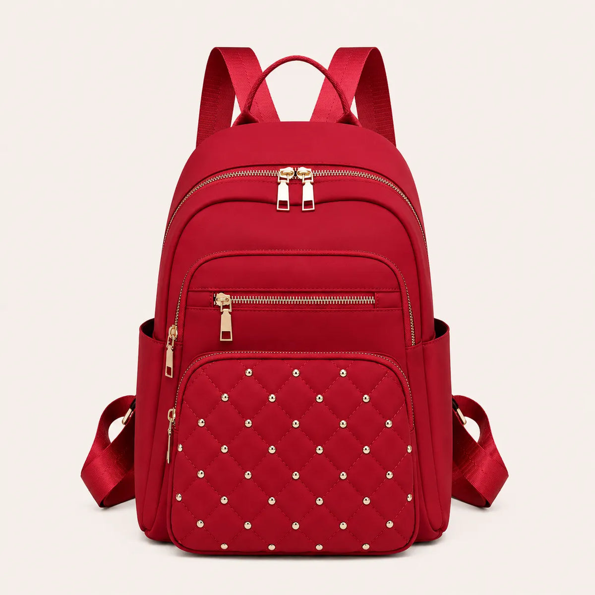 Sac à dos femme rouge matelassé avec détails dorés et poches zippées vu de face