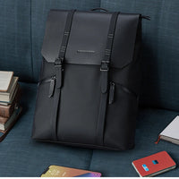 Le Classique, sac à dos ordinateur noir à rabat posé dans un intérieur moderne