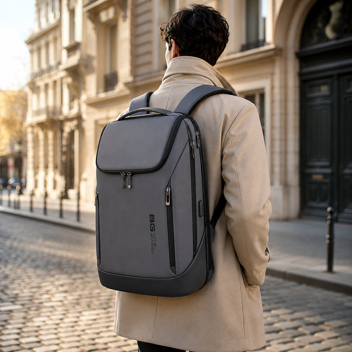 Homme élégant portant un sac à dos ordinateur rigide gris dans une rue parisienne au style urbain premium