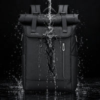 Le Nomade, sac à dos ordinateur Roll Top noir sous un jet d’eau