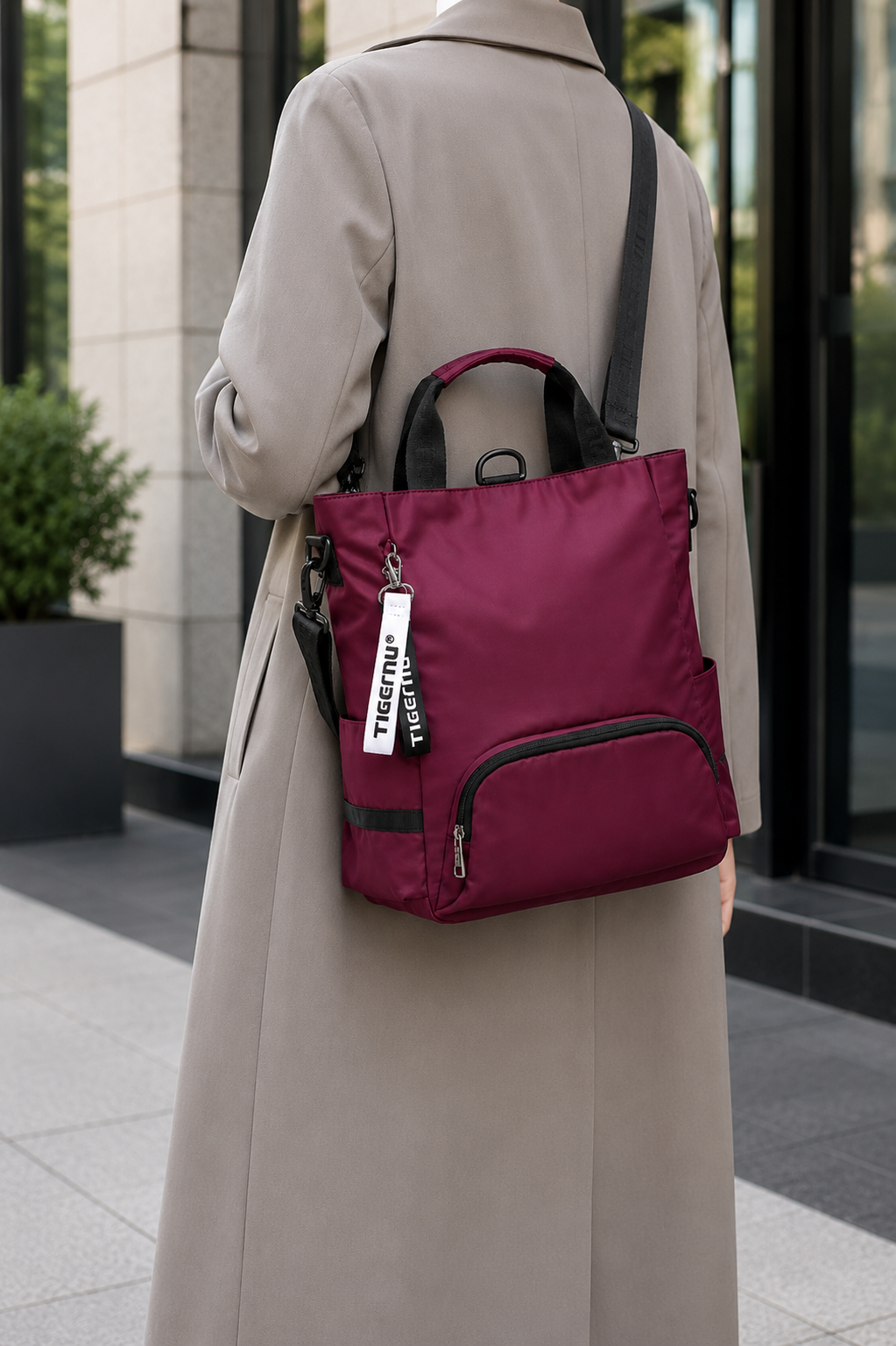 Sac ordinateur femme prune TIGERNU porté avec une veste longue professionnelle, silhouette discrète et style élégant pour un usage quotidien.