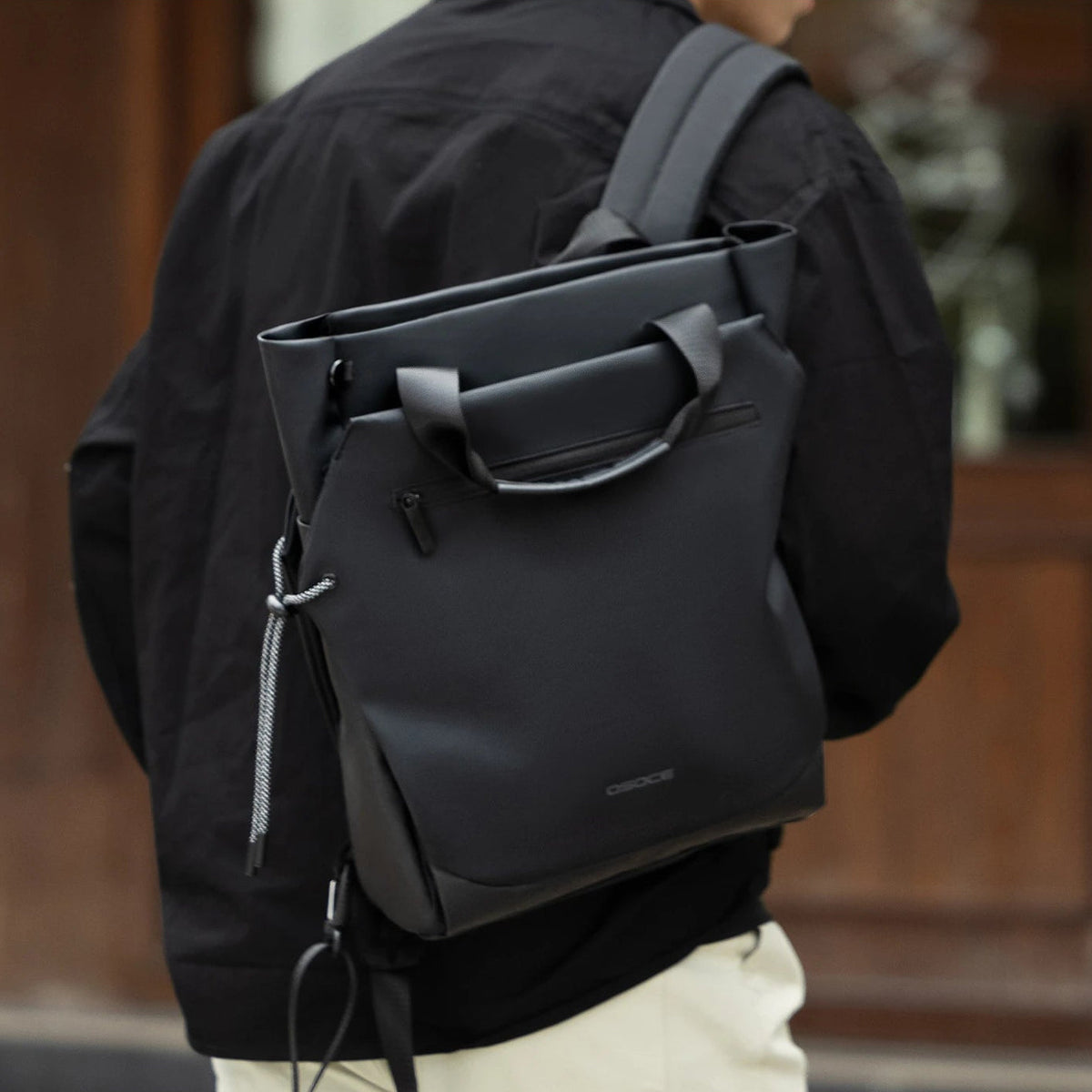 Le Tote noir porté en bandoulière