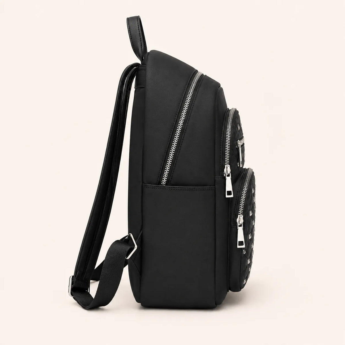 Vue latérale d’un sac à dos femme noir matelassé avec poches zippées et détails métalliques